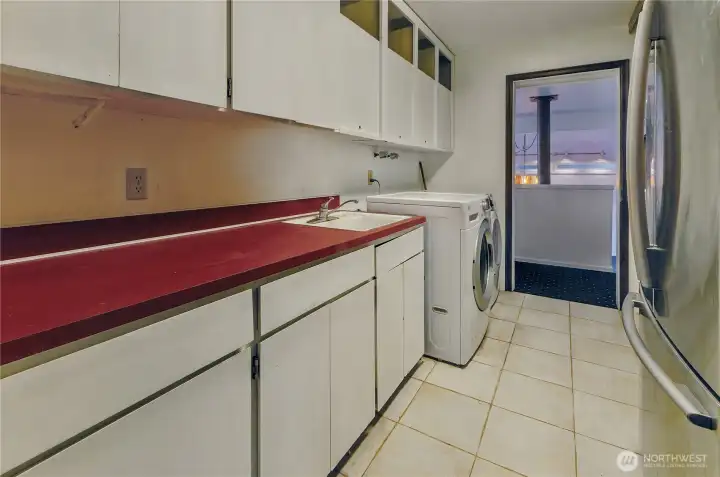 Spacious Laundry Area With Cabinets And Washer/Dryer