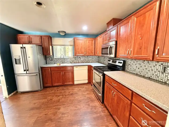 Spacious, bright kitchen with tons of cabinet storage.