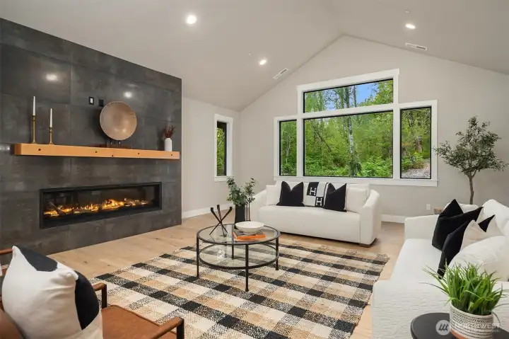Dramatic stone floor-to-ceiling gas fireplace accented by a beautiful wood mantel.
