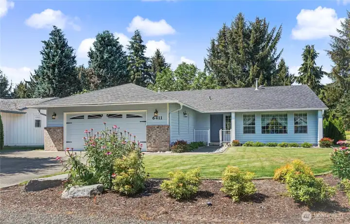 Front view of home, amazing curb appeal. I love the professionally landscaped yard front and back, the extra wide parking including side door for your golf cart, and dedicated off-street parking out front!