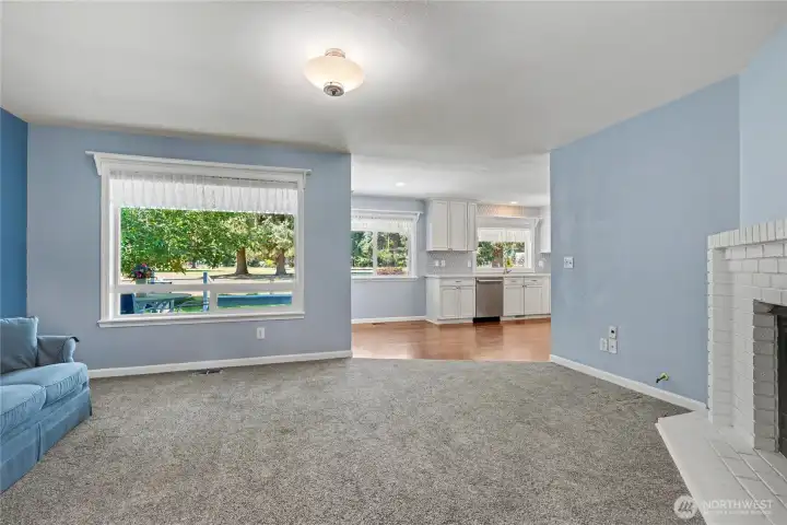 Family room view one towards kitchen, gas fireplace on your right to keep you cozy on cooler nights, HUGE window letting in all the light.