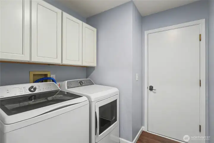 Utility room view with included washer and dryer, nice cabinetry and door leading to your garage.