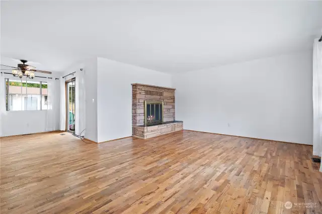 The living room is a bright and inviting space, featuring windows that flood the room with natural light. A central fireplace adds warmth and charm, creating a cozy focal point for gatherings.