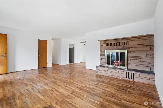 Here is another angle of the living room and fireplace. This perspective highlights the bright, inviting space with central fireplace and elegant hardwood floors.