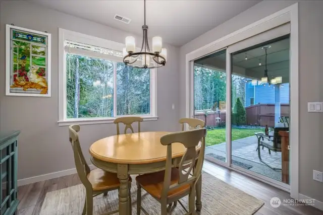 Diningroom with sliding glass doors that lead out to the covered patio with a double-sided fireplace to enjoy the outdoors year-round.