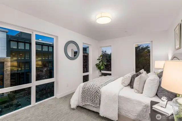 Step into the cozy elegance of this sunlit bedroom. Expansive windows frame serene views while filling the space with natural light, creating the perfect relaxing ambiance.