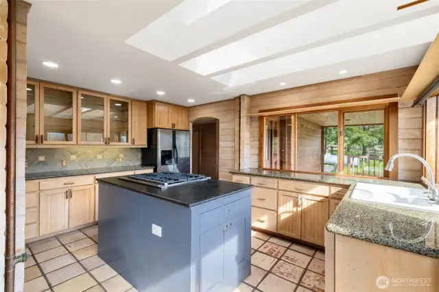 Skylit and sun-drenched, this kitchen brings the outdoors in with warm wood tones, garden views, and tons of natural light. With great bones and a functional layout, a few stylish updates could make it the heart of the home.