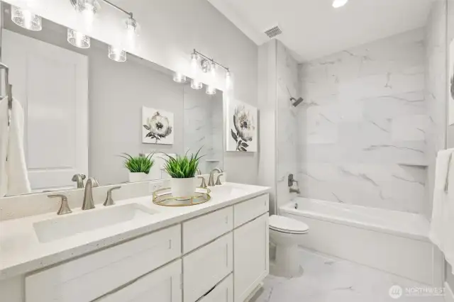 A luxurious feel to the lower level hall bath, dressed in quartz and extensive tile.