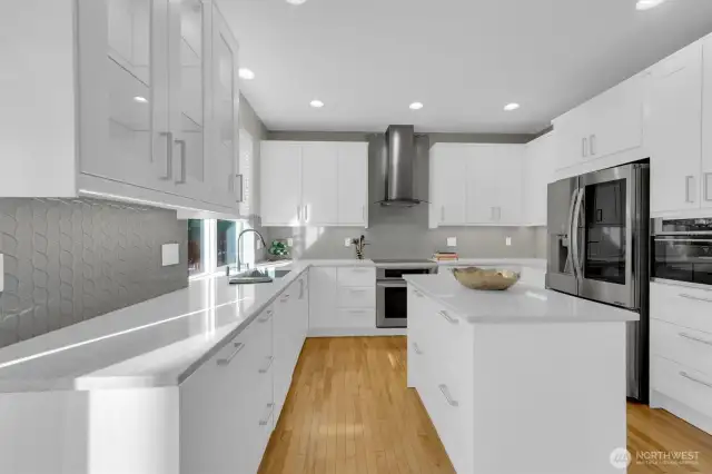 Beautiful full height glass backsplash really adds to the beauty of this kitchen
