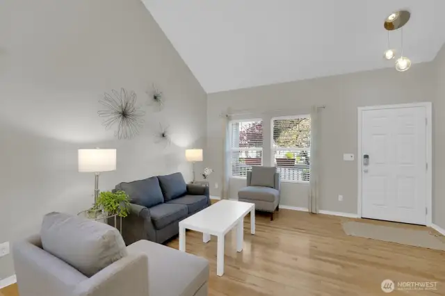 Lovely living room with vaulted ceilings & extensive hardwood floors.