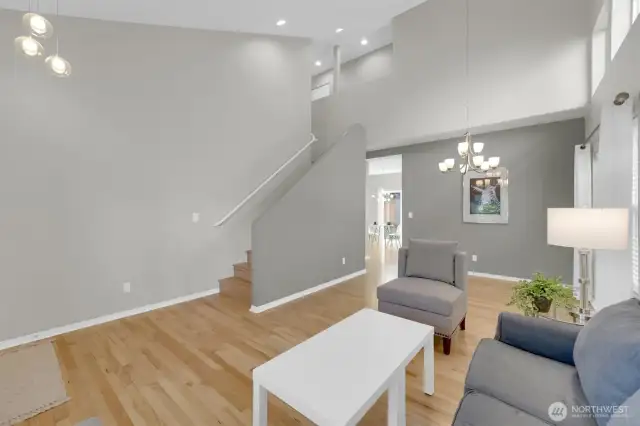 Living room/ dining room open to one another with tall ceilings for extra high impact.