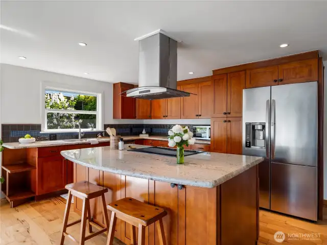 Kitchen has slab granite countertops, stainless steel appliances and a breakfast bar.