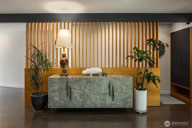 This entry space is gracious enough to accommodate a sizeable credenza.  In addition to paying homage to its midcentury roots, the slatted entry wall grants light into the hallway and stairwell.