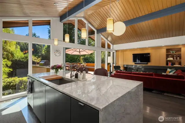 Floor-to-ceiling windows (and the deck) look down upon the secret-garden of a backyard.  Tall perimeter trees  provide amazing privacy, with the large corner lot also allowing abundant light to grace the yard, deck, and home.