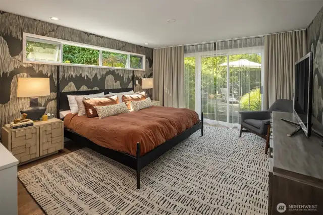 The Primary Suite is gracious in scale and beautifully-appointed, with designer wallpaper and sheer/blackout drapes.  A slider opens to a sweet patio.