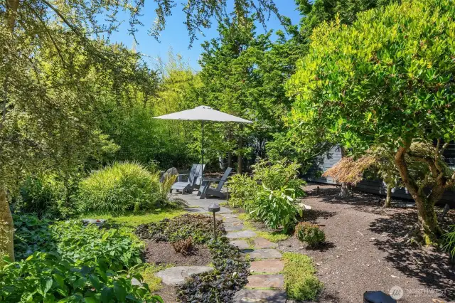 This is looking toward that patio space, tucked far to the right of the front entry, nestled into lush landscaping and privacy fence.