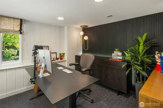A dark-stained wall and designer pendant light offers up a pretty sweet backdrop for video calls.