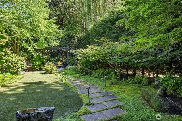 Your own secret garden!  That's artificial turf on the left, a nice patch of level/functional green...nicely contrasting against lush and very organic ground cover, with stone pavers bridging the two.