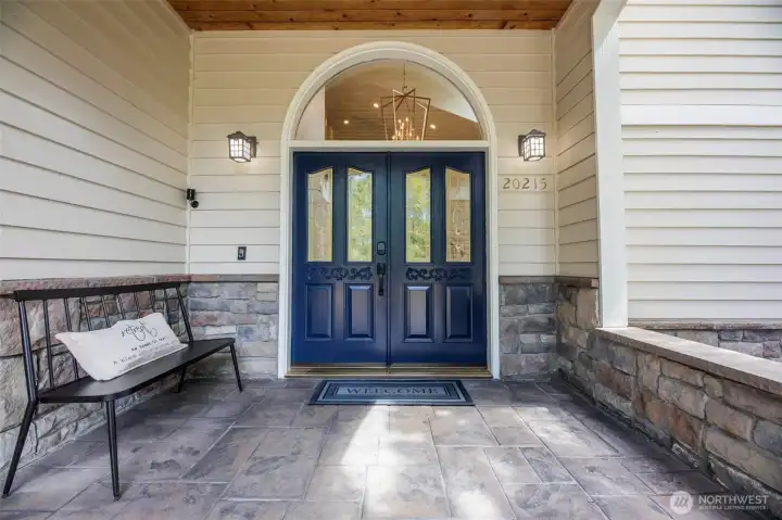 An inviting covered front porch with the continued stone accents.