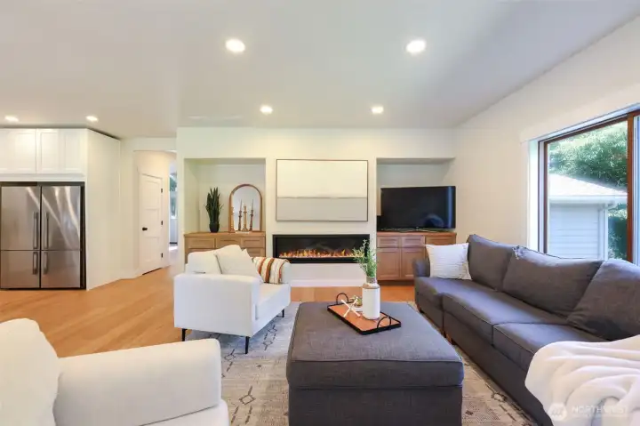 Family room with custom built-ins and 60” gas fireplace with ambient backlighting