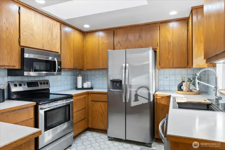 Kitchen has all SS appliances, tile backsplash & plenty of natural light from the skylight!