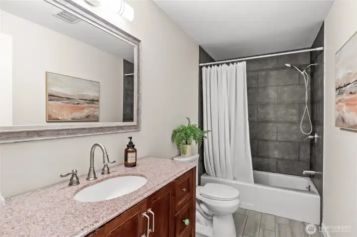Shared between the secondary and third bedrooms, this main floor bathroom freshly remodeled with new tile and grout is ready when you are!