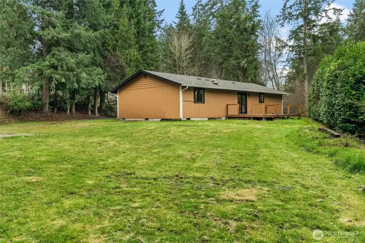 Escape the everyday in your own backyard retreat. This secluded deck provides a serene vantage point to enjoy the vast landscaping and quiet surroundings.