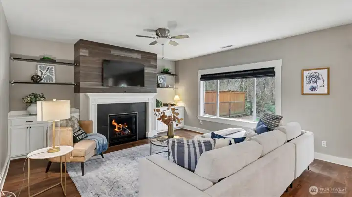 Perfect for relaxing evenings, this living room offers a cozy fireplace and serene views outside.