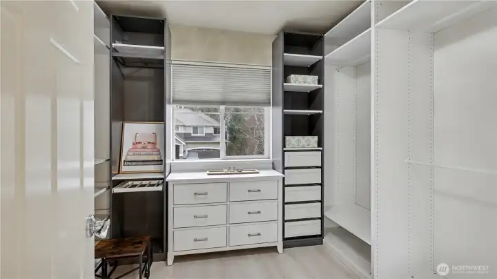The spacious primary walk-in closet features custom built-ins, drawers, and shelving for effortless organization.