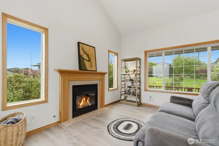 Living room window frames lovely mature landscaping, creating a natural privacy barrier from the street while bringing in peaceful greenery views.