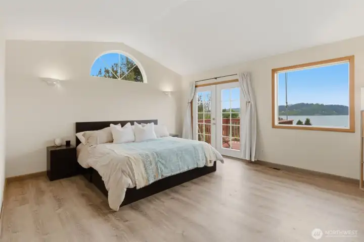 Upper-level primary bedroom features its own private deck and peaceful water views you can enjoy right from bed.