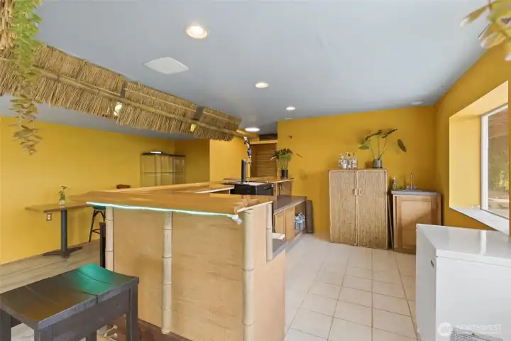 Behind the tiki bar, the host’s prep area offers generous space, complete with a kegerator topped with a striking orca detail that captures the Pacific Northwest spirit.