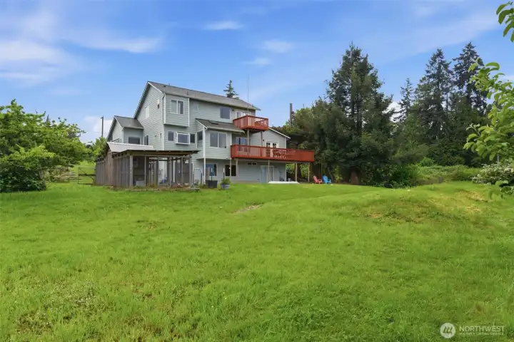View from the back of the home showcasing the peaceful setting and newer roof installed in 2023.