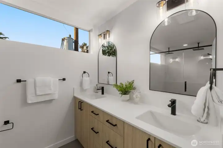 Double vanities, double style — Matte black accents, designer lighting, and dual sinks make this bathroom feel fresh and thoughtfully designed.