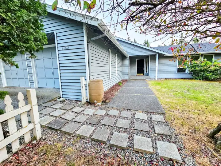 Single-level rambler on a flat, open corner lot with an attached two-car garage and a wide concrete driveway. Single-level rambler on a flat, open corner lot with an attached two-car garage and a wide concrete driveway.