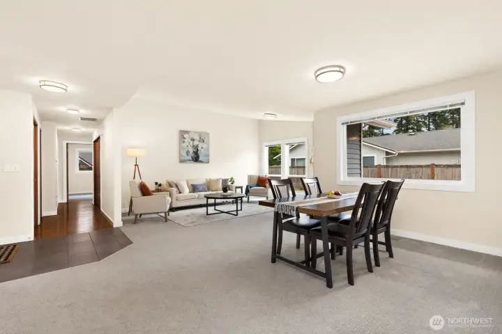 Bright, open living and dining space with a clear view down the hall to all three bedrooms. Bright, open living and dining space with a clear view down the hall to all three bedrooms.