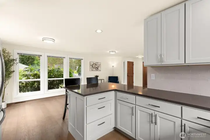 Generous counter space, hexagonal tile backsplash, and a wall of windows flooding the kitchen with natural light. Generous counter space, hexagonal tile backsplash, and a wall of windows flooding the kitchen with natural light.
