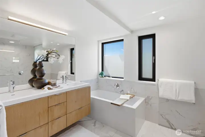 Calacatta-pattern Pental® stone tile floor to ceiling, Grohe® and Hansgrohe® fixtures, a sculpted soaking tub, and a Toto® wall-hung toilet. Calacatta-pattern Pental® stone tile floor to ceiling, Grohe® and Hansgrohe® fixtures, a sculpted soaking tub, and a Toto® wall-hung toilet.