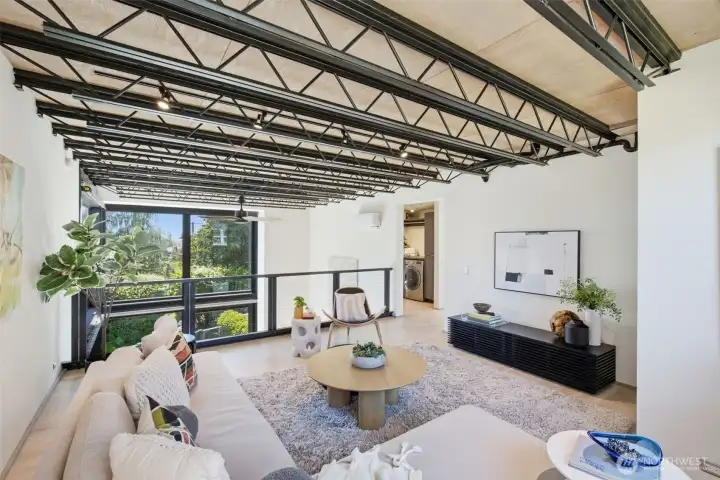 Open-web steel trusses overhead, patterned after the tree canopy outside — engineering left exposed because it was built to be looked at. Open-web steel trusses overhead, patterned after the tree canopy outside — engineering left exposed because it was built to be looked at.