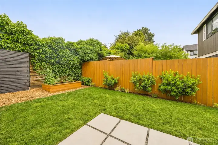 Spacious private fenced-in backyard with garden boxes and hardscaping. Spacious private fenced-in backyard with garden boxes and hardscaping.