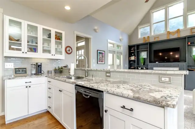 Glass cabinetry, stainless sink and pullout faucet.  Custom tile backsplash.