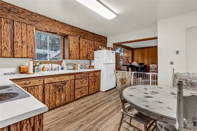 The kitchen in this home has handmade wood cabinets and trim. The brown color of the cabinets and trim accents the newer laminate flooring very nicely.