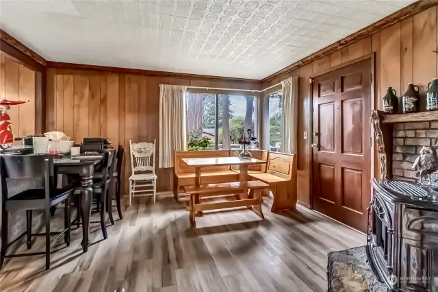Another view of the Dining area and front Entry with gas free standing stove. Perfect for gatherings.
