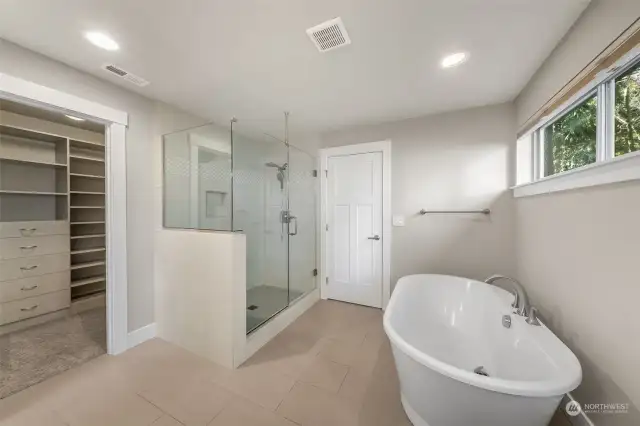 Indulge in the elegance of this master bathroom, featuring a stunning glass-surround shower that offers a sleek, modern look and a spa-like experience.