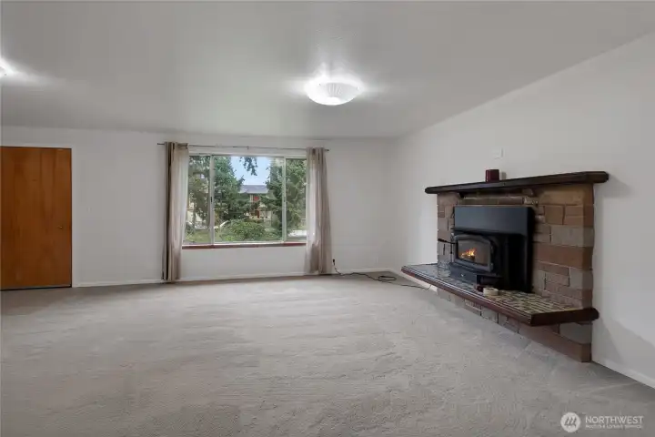 Another view of living room with wood burning stove.