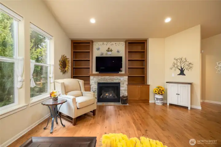 Gas fireplace anchors the room with stone surround