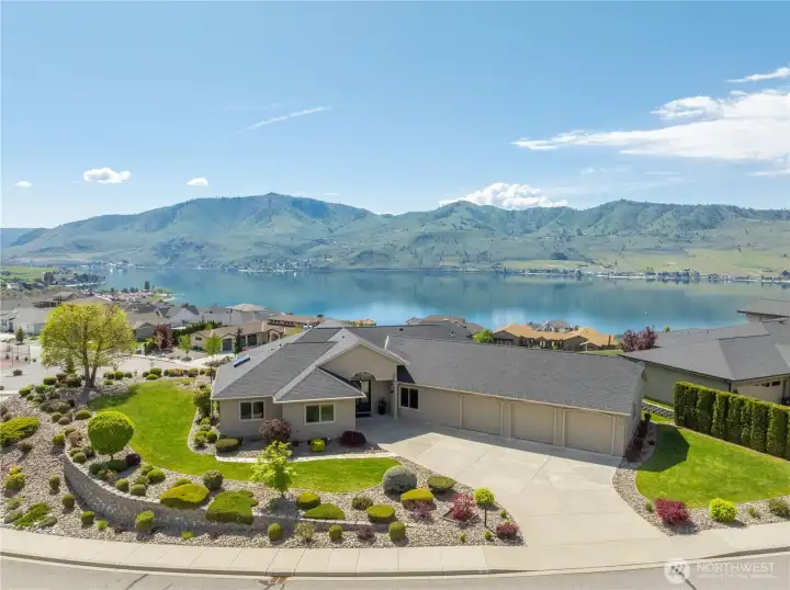 Elevated above Lake Chelan in desirable Crystal View Estates, this stunning residence captures sweeping panoramic views of the lake, surrounding mountains, and golf course. Beautifully landscaped grounds and a spacious driveway create a grand approach, while the home’s positioning maximizes privacy and scenery. Enjoy resort-style outdoor living with an in-ground pool perfectly framed by the breathtaking backdrop—ideal for entertaining or relaxing in the Chelan sunshine.