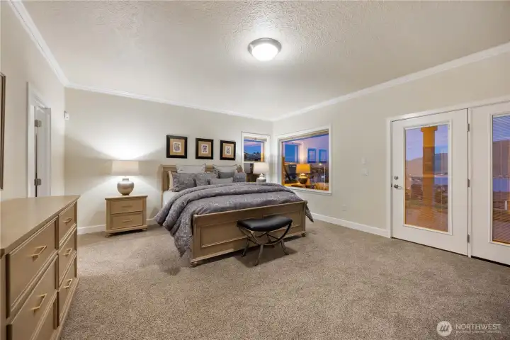 Expansive primary suite offering a peaceful retreat with plush carpeting, ample space for a sitting area, and abundant natural light. Thoughtfully designed with direct access to the en suite bath and walk-in closet, creating a comfortable and functional private sanctuary.