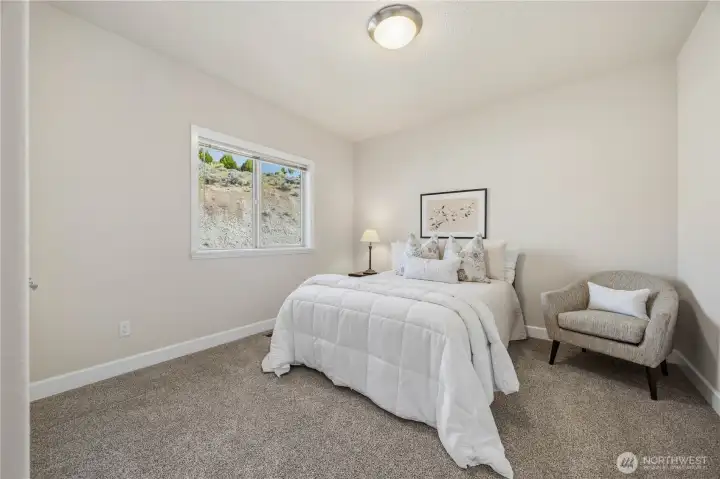 Comfortable guest bedroom featuring soft carpeting, neutral tones, and a bright window that brings in natural light. A welcoming and versatile space perfect for visitors or additional living needs.