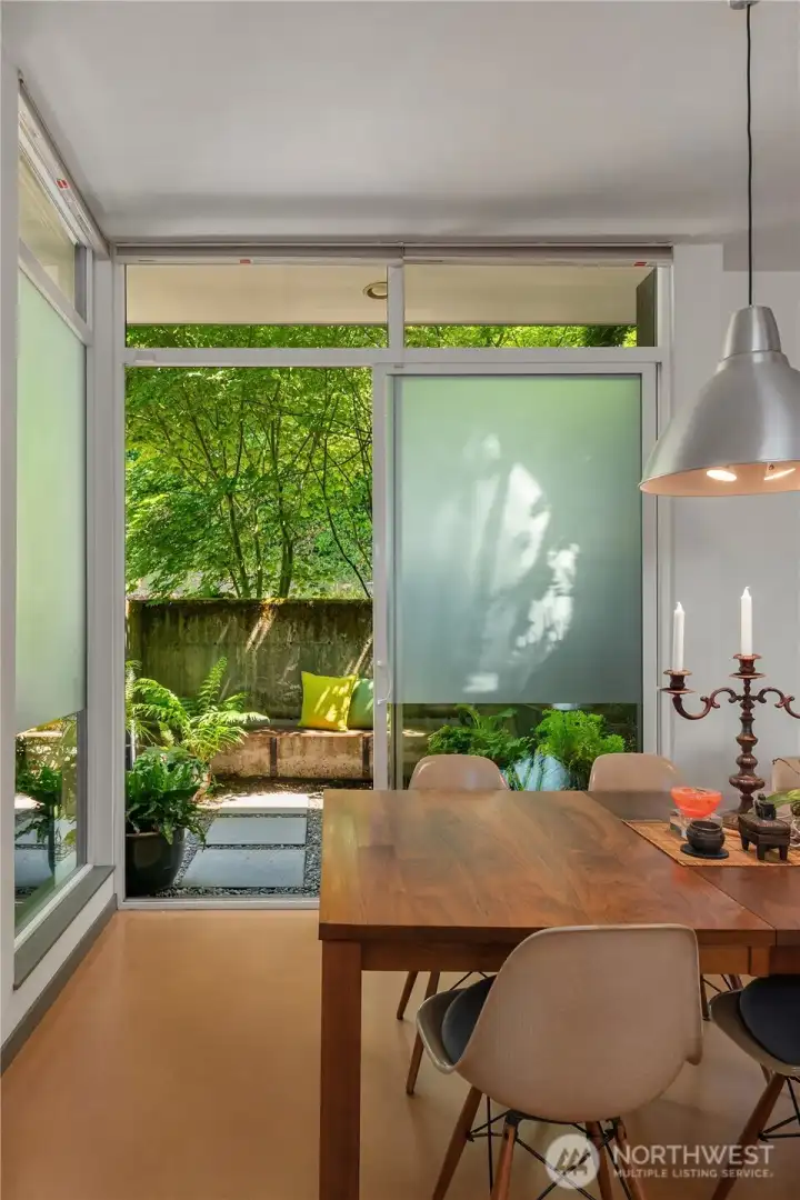 The dining area opens onto the lush entry courtyard, flooded with morning light.